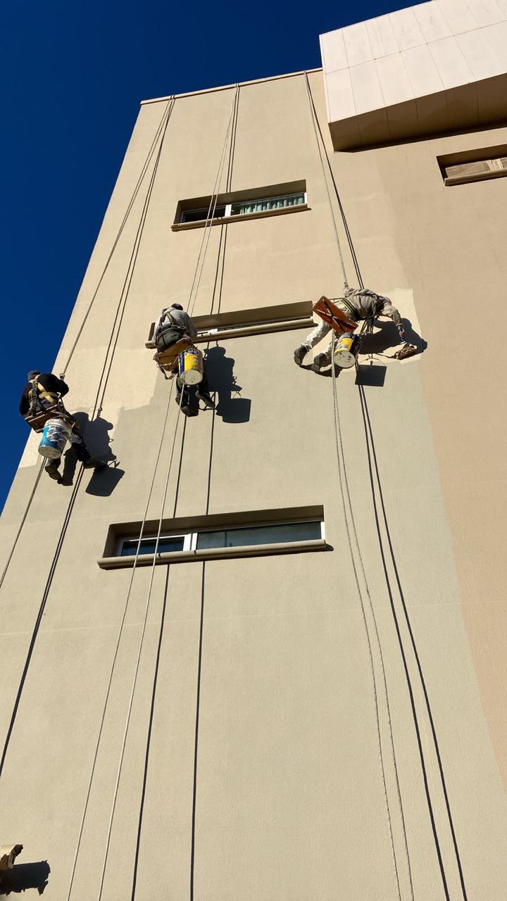 Equipo de pintores trabajando en fachada